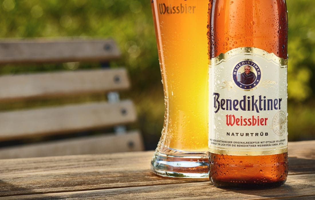 Chai và ly Benediktiner Weissbier trong không gian ngoài trời